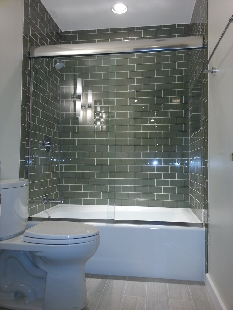 Photo of a mid-sized contemporary kids bathroom in Charlotte with an alcove tub, a shower/bathtub combo, green tile, subway tile, white walls and porcelain floors.