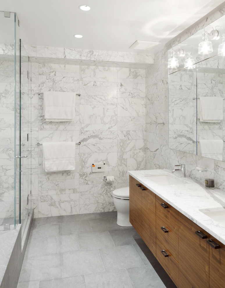 Photo of a contemporary bathroom in New York with an undermount sink, flat-panel cabinets, a corner shower, white tile, white walls and white benchtops.