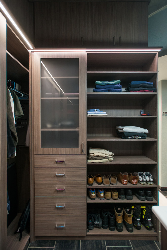 Mid-sized modern men's walk-in wardrobe in Denver with flat-panel cabinets, medium wood cabinets, ceramic floors, grey floor and vaulted.