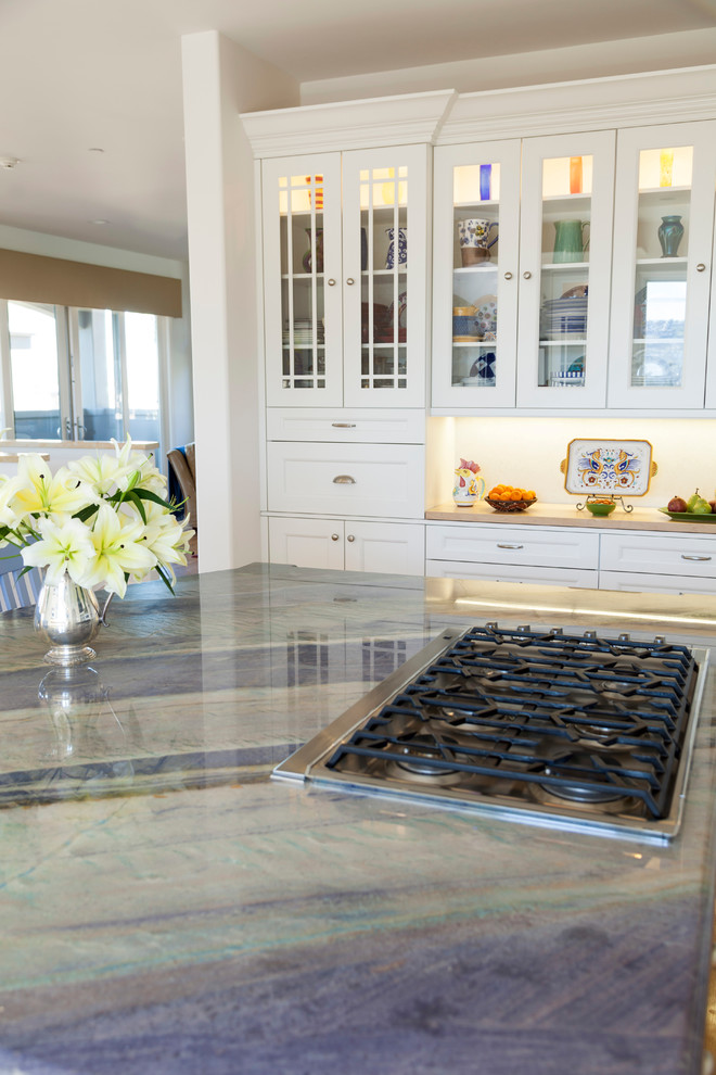 Example of a large transitional light wood floor eat-in kitchen design in Los Angeles with an undermount sink, recessed-panel cabinets, white cabinets, quartzite countertops, gray backsplash, stone slab backsplash, paneled appliances and an island