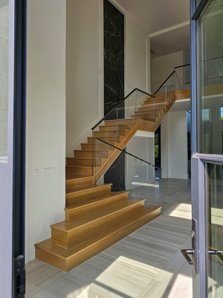 Inspiration for an expansive contemporary wood floating staircase in DC Metro with wood risers, mixed railing and decorative wall panelling.