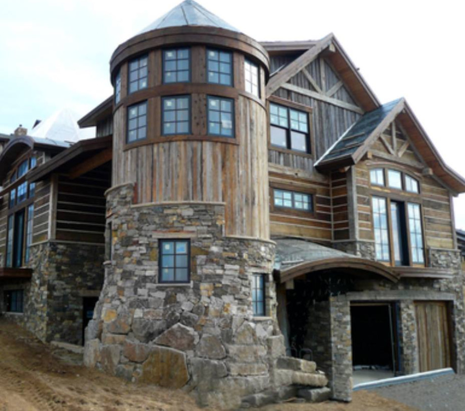 Inspiration for a large rustic beige two-story stone gable roof remodel in Phoenix