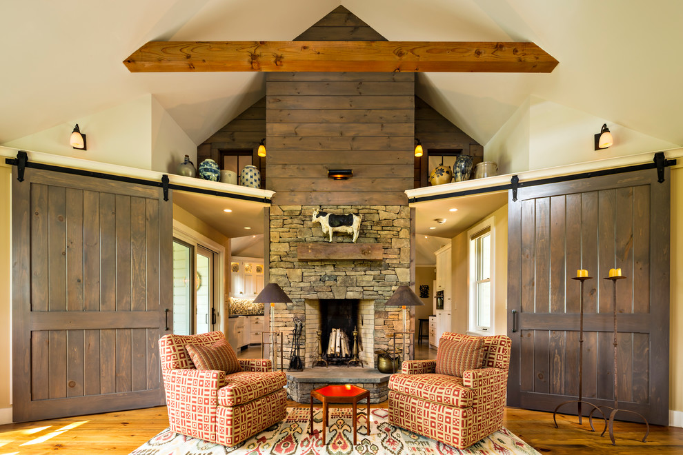 Inspiration for a country formal enclosed living room in New York with beige walls, light hardwood floors, a standard fireplace and a stone fireplace surround.