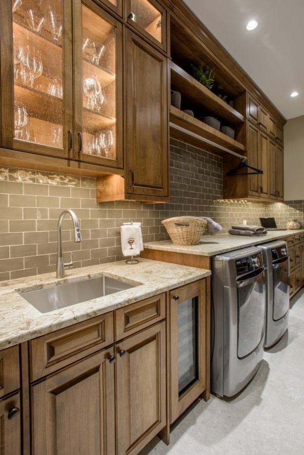 Inspiration for a large traditional galley utility room in Denver with an undermount sink, raised-panel cabinets, dark wood cabinets, granite benchtops, grey walls, concrete floors, a side-by-side washer and dryer and grey floor.