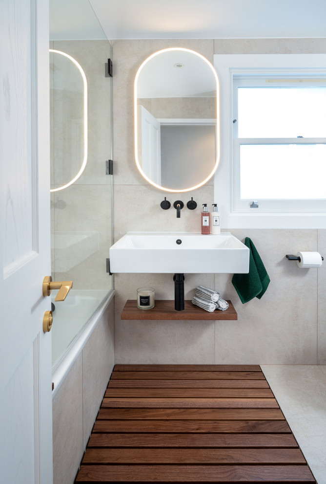 This is an example of a mid-sized scandinavian kids bathroom in London with dark wood cabinets, a drop-in tub, a wall-mount toilet, gray tile, porcelain tile, grey walls, dark hardwood floors, a wall-mount sink, brown floor, a single vanity and a floating vanity.