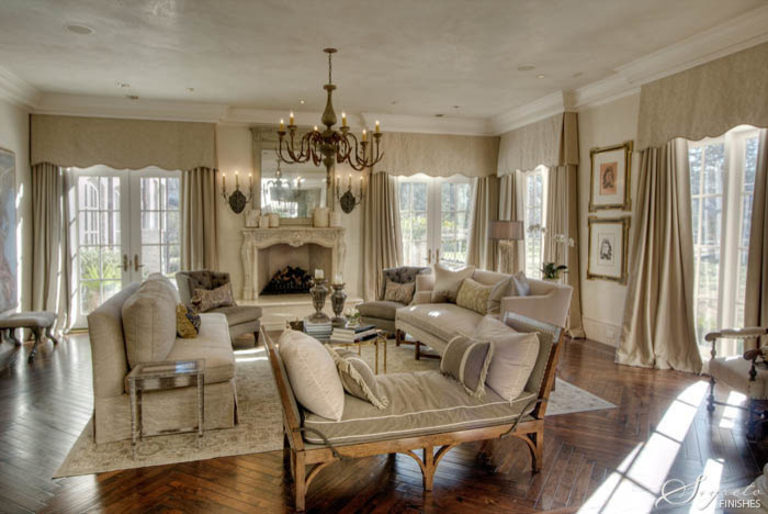 This is an example of a large traditional formal enclosed living room in Houston with beige walls, dark hardwood floors, a hanging fireplace and a stone fireplace surround.