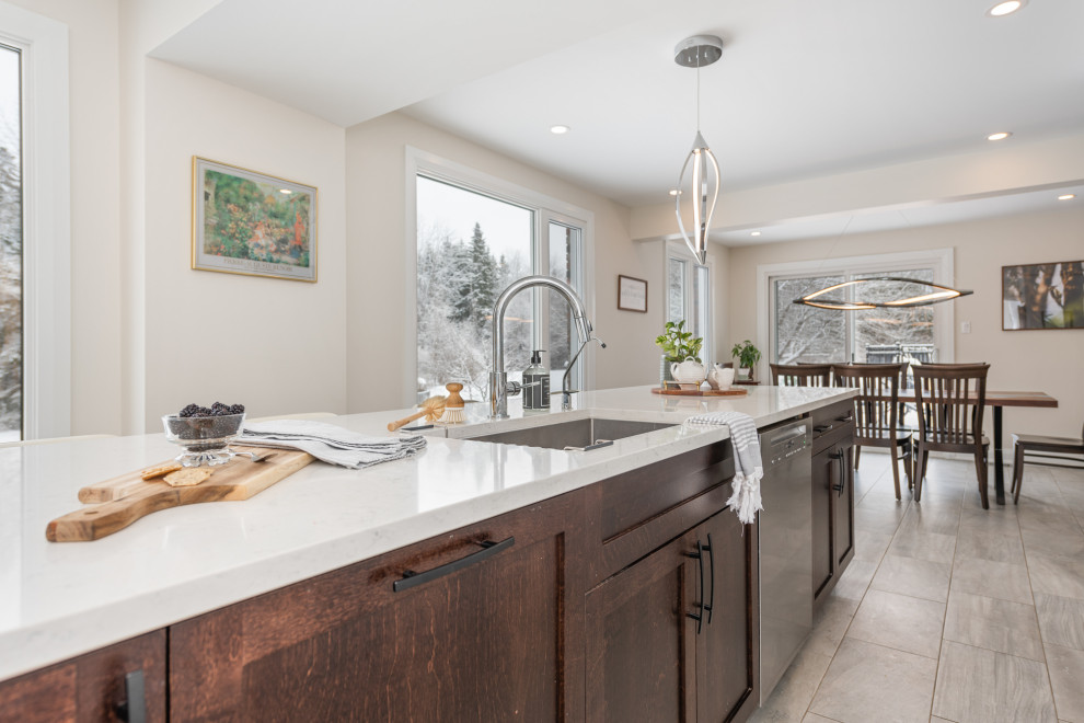Minimalist eat-in kitchen photo in Ottawa with an island, an undermount sink, shaker cabinets, brown cabinets, quartz countertops, stainless steel appliances and white countertops
