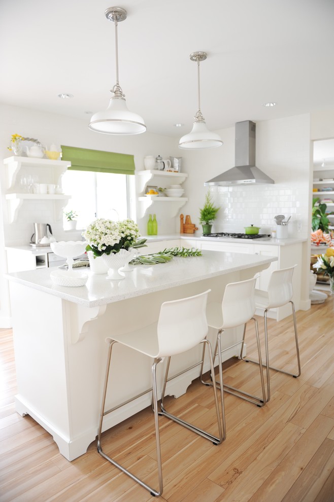 Design ideas for a mid-sized transitional l-shaped separate kitchen in Vancouver with an undermount sink, open cabinets, white cabinets, quartz benchtops, white splashback, ceramic splashback, stainless steel appliances and laminate floors.