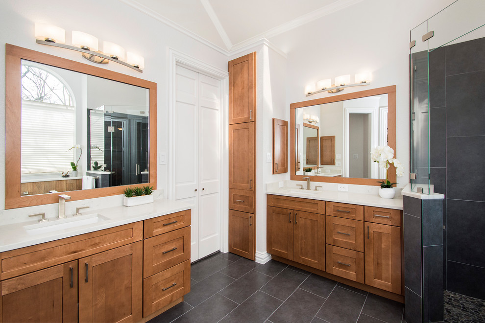 Mid-sized elegant master gray tile and porcelain tile porcelain tile and gray floor freestanding bathtub photo in Dallas with flat-panel cabinets, brown cabinets, a one-piece toilet, gray walls, an undermount sink, quartzite countertops, a hinged shower door and white countertops