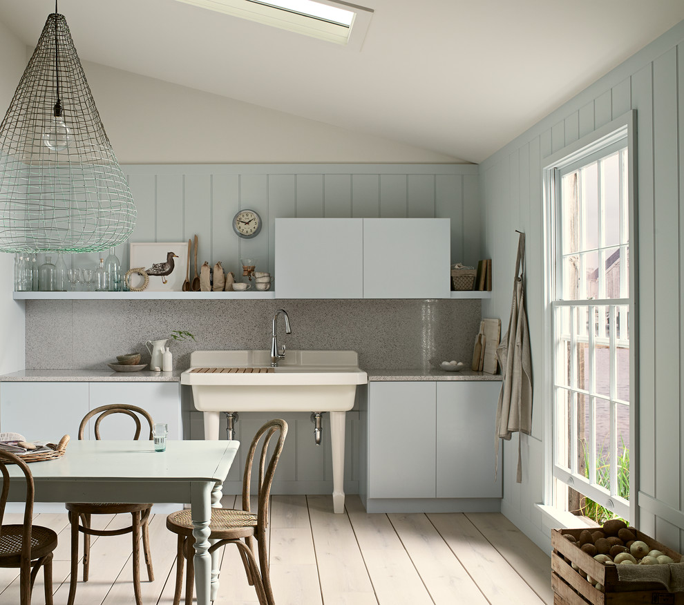 Example of a mid-sized beach style single-wall light wood floor and beige floor eat-in kitchen design in Milwaukee with a farmhouse sink, flat-panel cabinets, blue cabinets, quartz countertops, gray backsplash, stone slab backsplash and no island