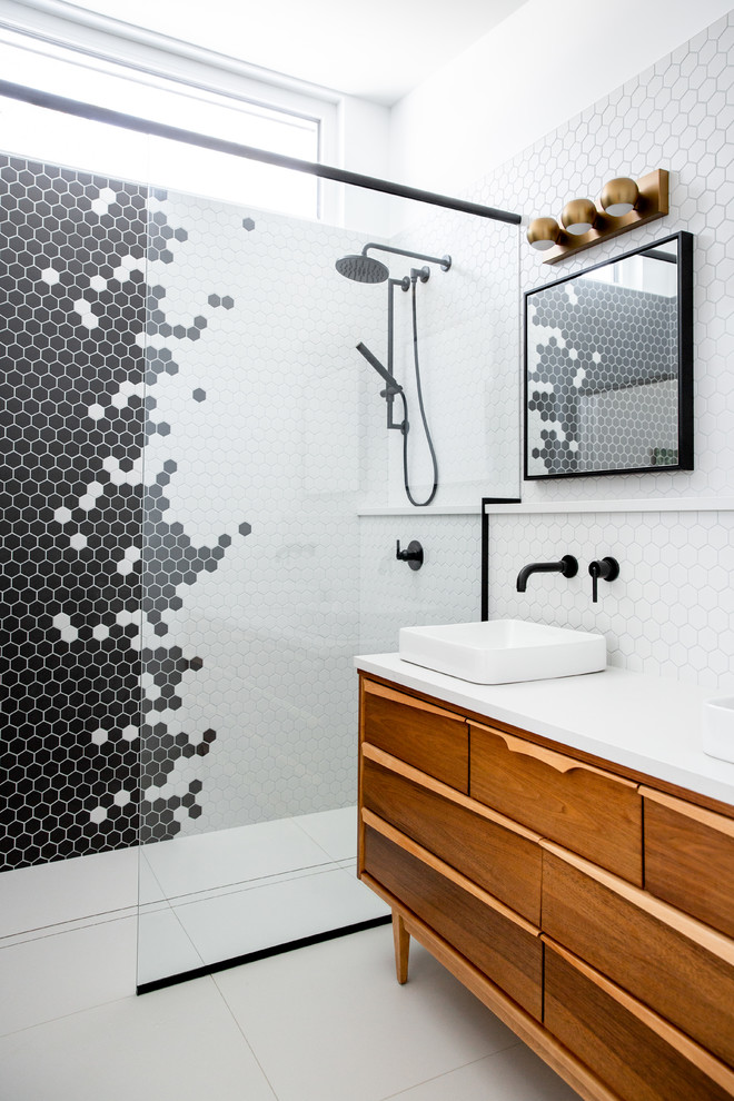 Inspiration for a midcentury 3/4 bathroom in Calgary with medium wood cabinets, black tile, black and white tile, multi-coloured tile, white tile, mosaic tile, white walls, a vessel sink, white floor, white benchtops and flat-panel cabinets.