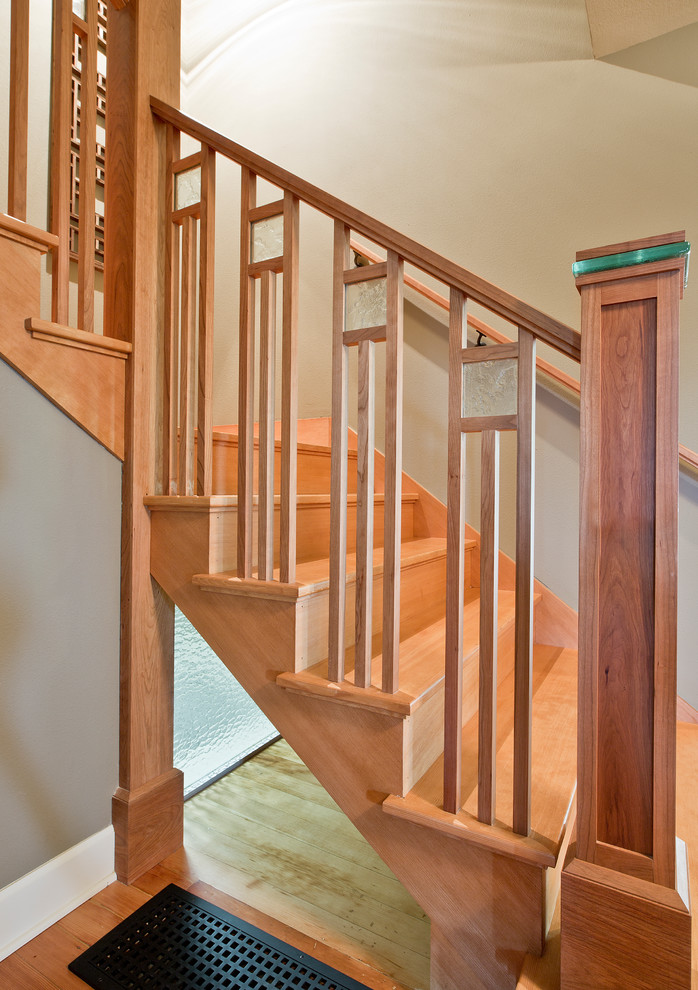 This is an example of a large arts and crafts wood l-shaped staircase in Seattle with wood risers.