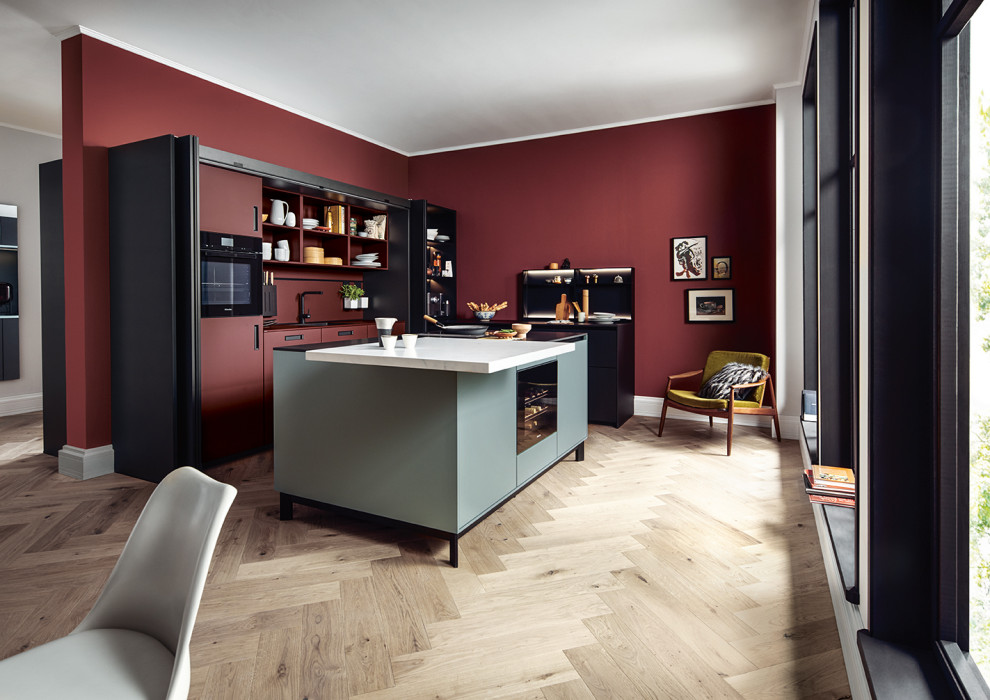 Design ideas for a large asian l-shaped open plan kitchen in Nuremberg with flat-panel cabinets, black cabinets, red splashback, black appliances, with island and white benchtop.