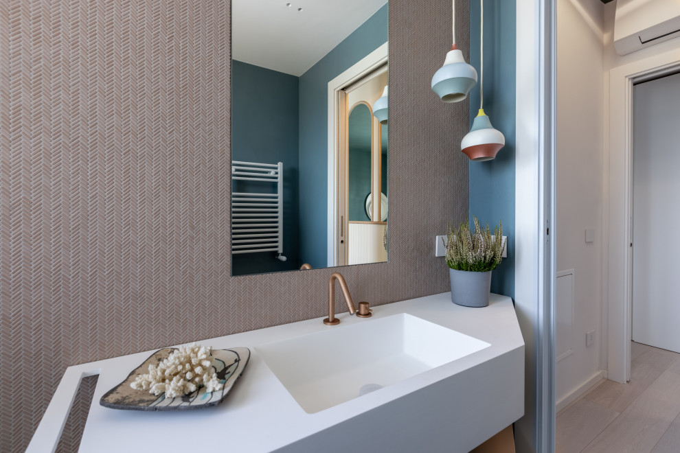 На фото: маленькая главная ванная комната в стиле модернизм с синими фасадами, накладной ванной, душем над ванной, раздельным унитазом, розовой плиткой, плиткой мозаикой, синими стенами, бетонным полом, монолитной раковиной, столешницей из искусственного камня, синим полом, душем с распашными дверями, белой столешницей, тумбой под одну раковину и подвесной тумбой для на участке и в саду с
