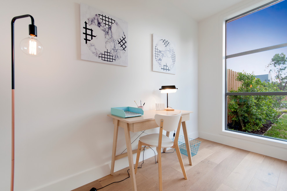 This is an example of a small scandinavian study room in Melbourne with white walls, light hardwood floors and a freestanding desk.