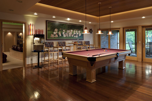 Traditional styled game room with a billiard table and four bar stools with arms and pub tables