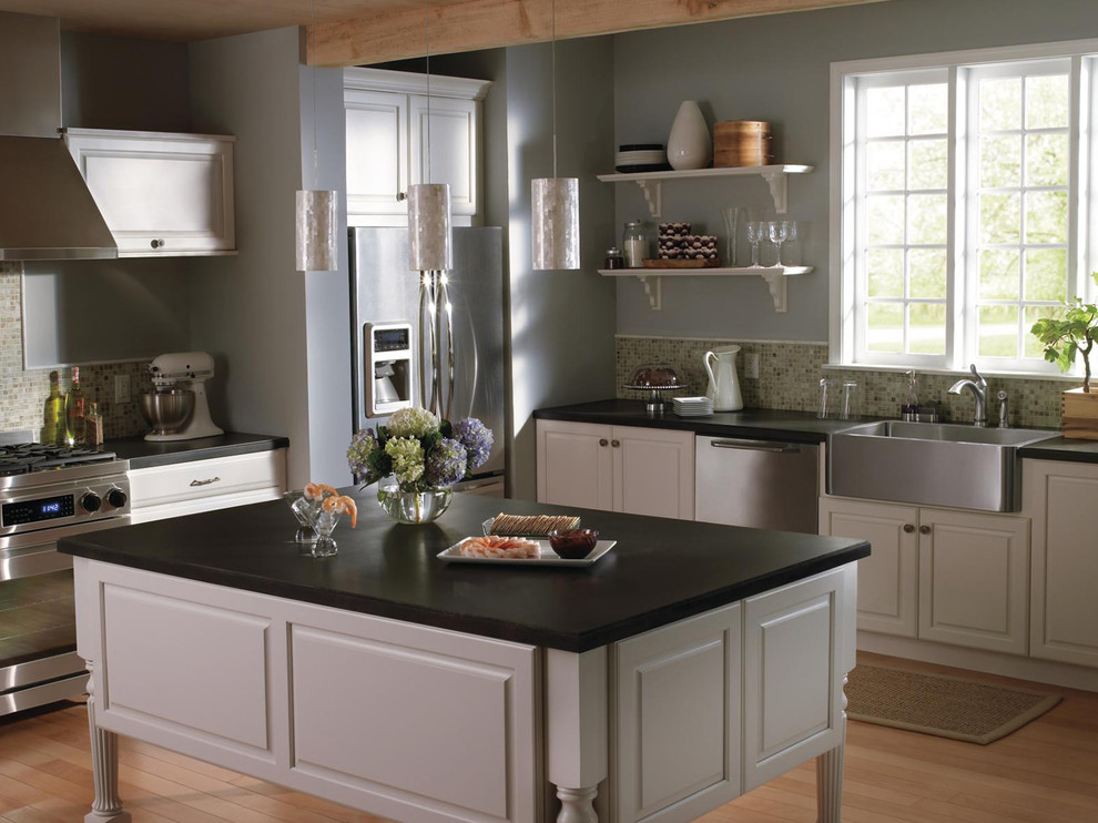 Example of a large transitional l-shaped light wood floor and brown floor kitchen design in Indianapolis with a farmhouse sink, white cabinets, multicolored backsplash, stainless steel appliances and an island