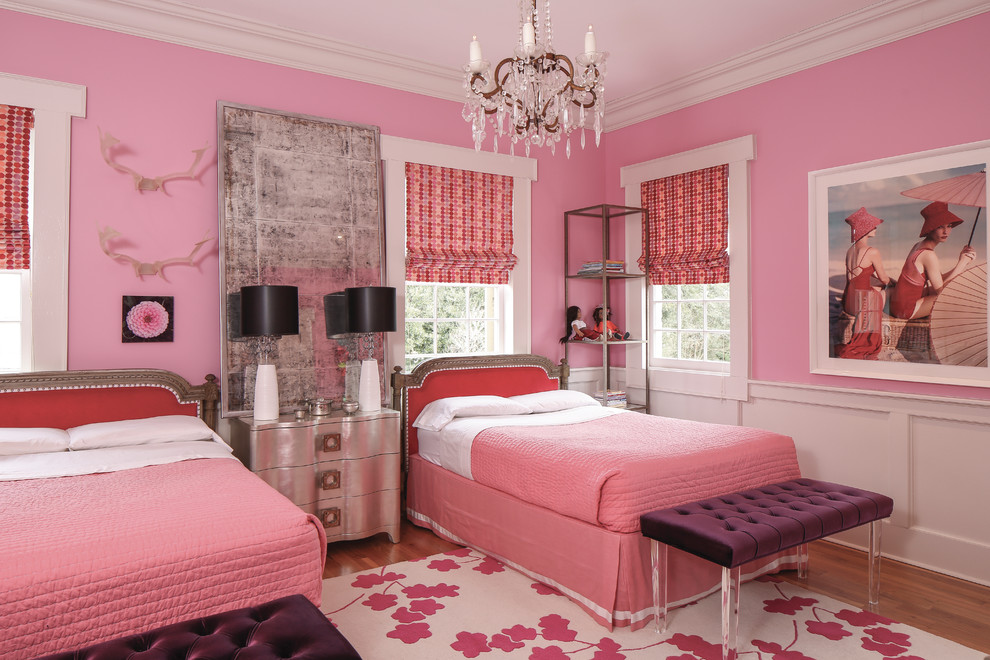 Photo of a traditional kids' bedroom for girls in Nashville with pink walls and medium hardwood floors.