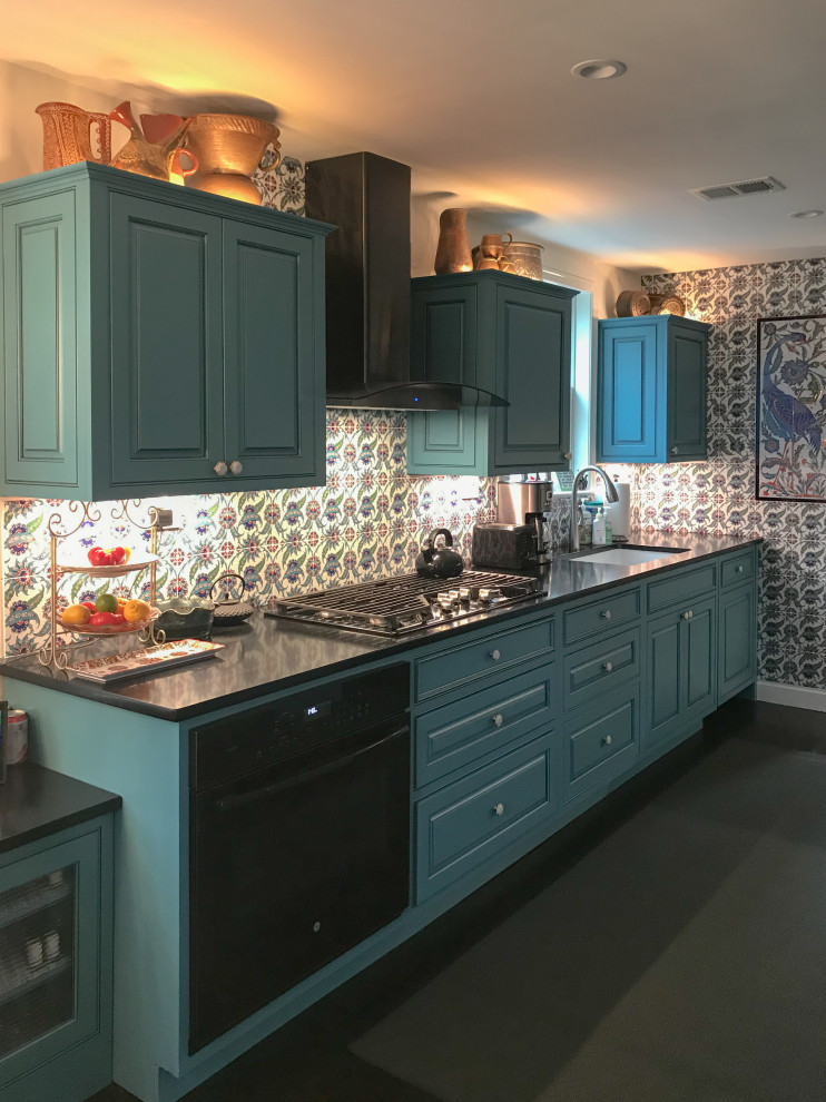Medium sized eclectic galley kitchen/diner in DC Metro with a submerged sink, beaded cabinets, blue cabinets, multi-coloured splashback and integrated appliances.