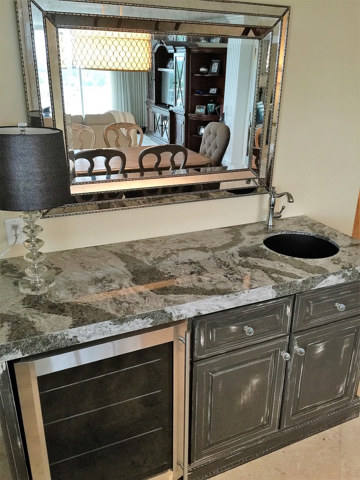 Small transitional single-wall wet bar in Other with an undermount sink, raised-panel cabinets, grey cabinets, quartz benchtops, travertine floors and beige floor.