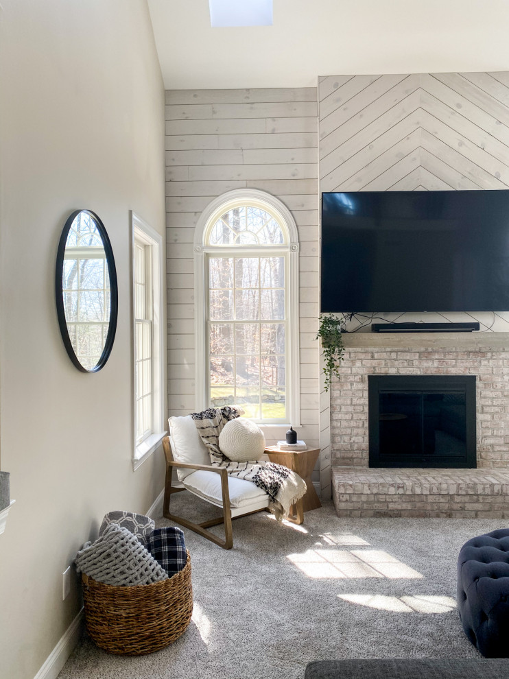 Design ideas for a large rural open plan living room feature wall in New York with beige walls, carpet, a standard fireplace, a brick fireplace surround, a wall mounted tv, beige floors, a vaulted ceiling and tongue and groove walls.