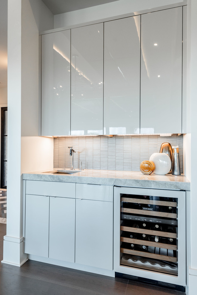 Inspiration for a mid-sized contemporary single-wall wet bar in Charleston with an undermount sink, flat-panel cabinets, grey cabinets, marble benchtops, grey splashback, metal splashback, medium hardwood floors, brown floor and grey benchtop.