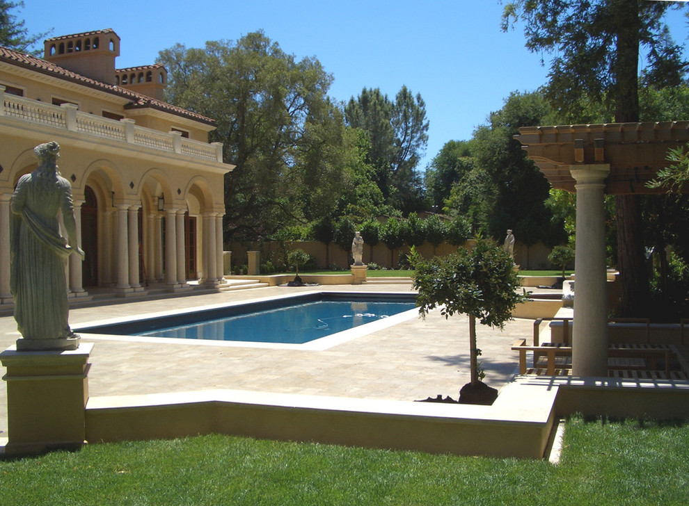 This is an example of a large mediterranean backyard formal garden in San Francisco with natural stone pavers.