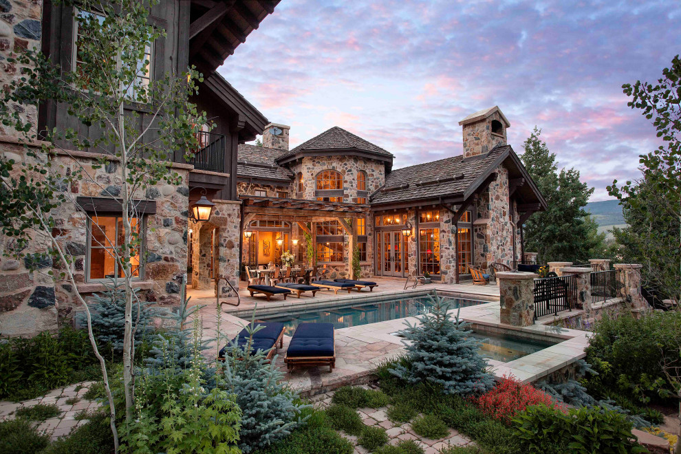 Inspiration for a country rectangular pool in Denver with natural stone pavers.