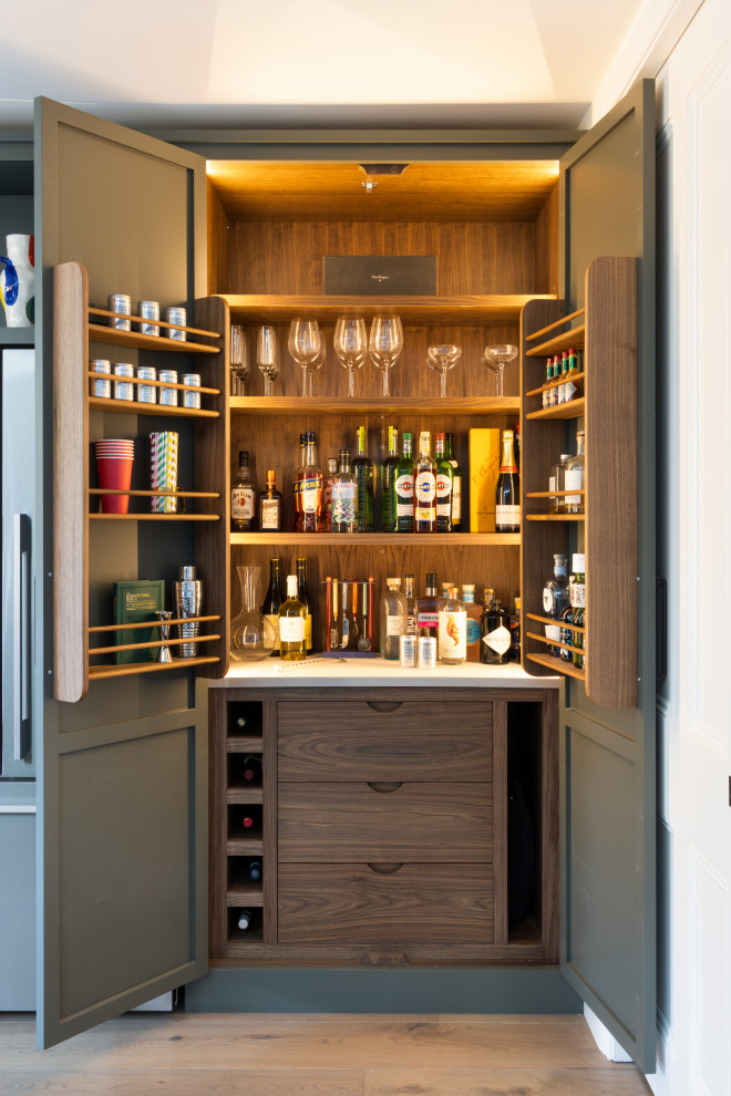 Exemple d'une cuisine américaine chic en L de taille moyenne avec un évier encastré, un placard à porte shaker, un plan de travail en béton, un électroménager en acier inoxydable, parquet clair, îlot et un plan de travail gris.