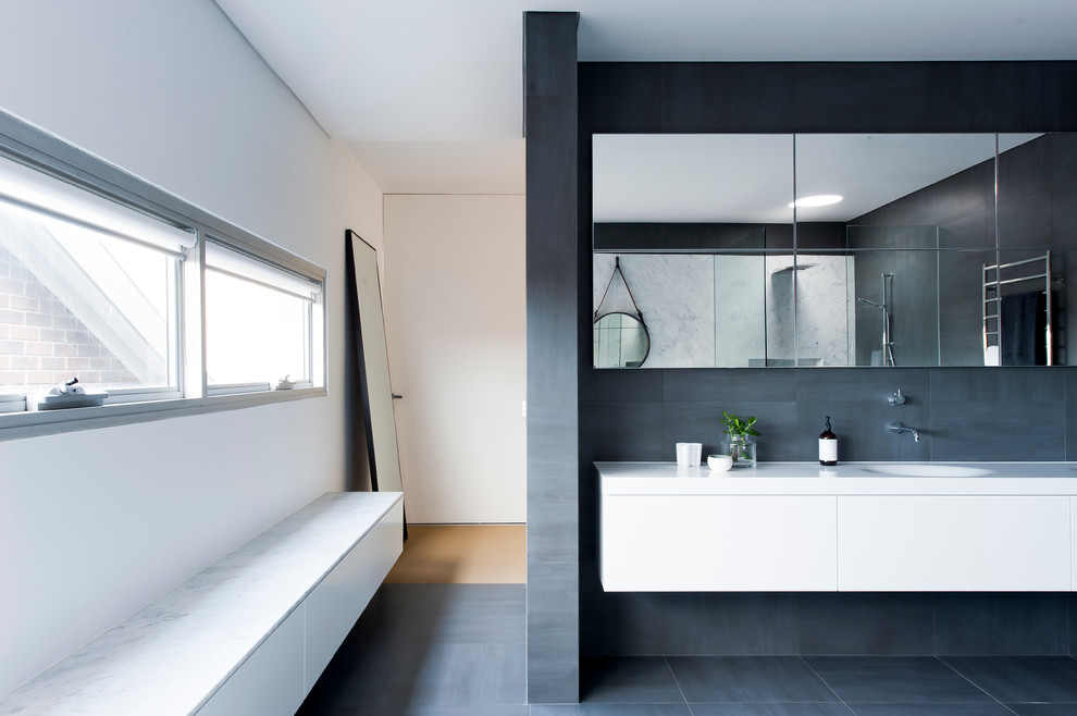 Design ideas for a large contemporary master bathroom in Sydney with furniture-like cabinets, white cabinets, solid surface benchtops, a freestanding tub, an open shower, gray tile, stone slab, grey walls and ceramic floors.