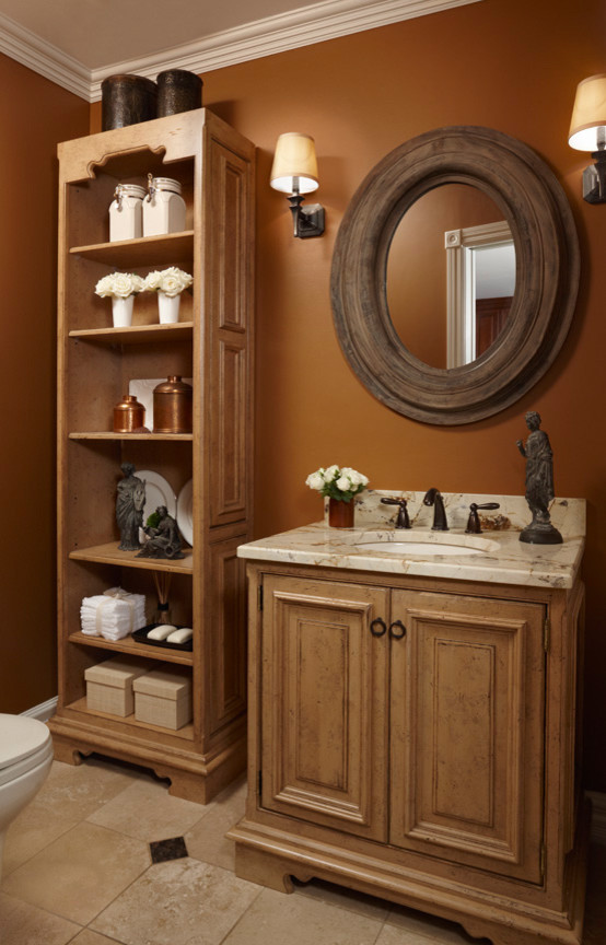 Inspiration for a small traditional bathroom in Detroit with an undermount sink, furniture-like cabinets, distressed cabinets, a two-piece toilet, beige tile, stone tile, orange walls, travertine floors, beige floor and beige benchtops.