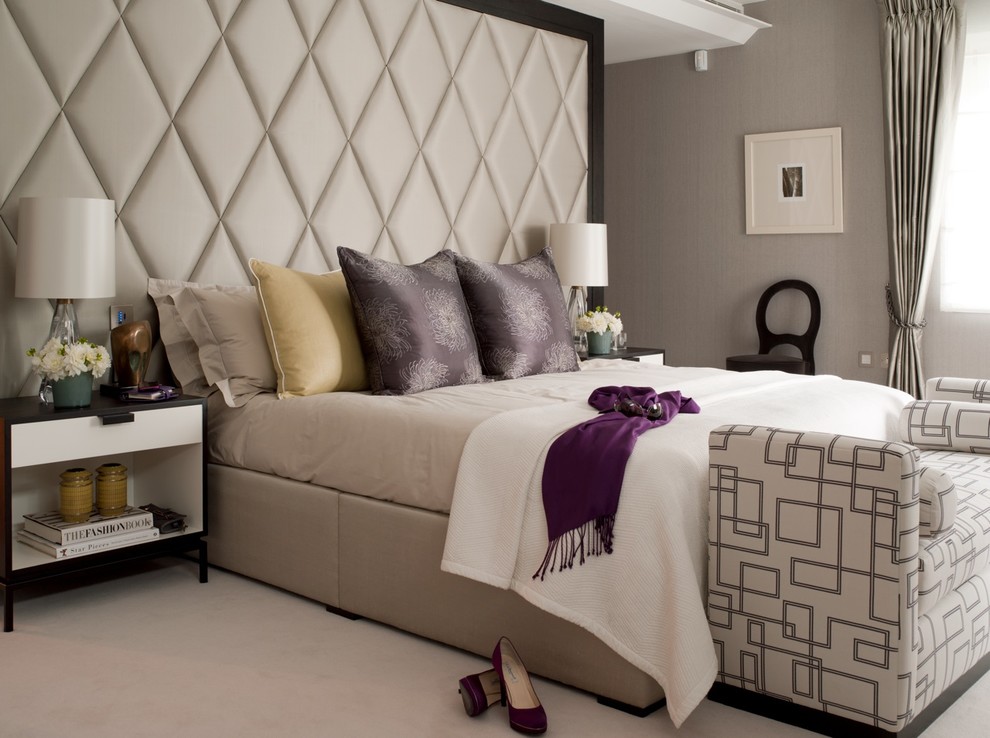 This is an example of a transitional bedroom in London with beige walls and carpet.
