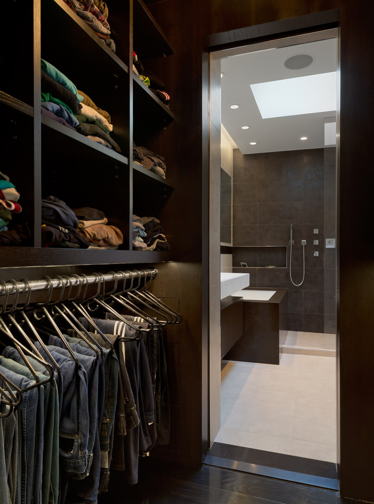 Inspiration for a small modern men's walk-in wardrobe in New York with open cabinets, dark wood cabinets and dark hardwood floors.