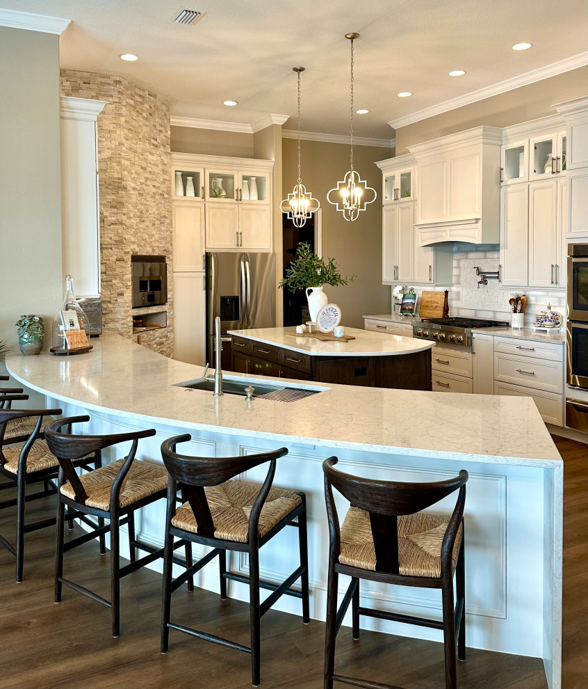 Large transitional kitchen photo in Orlando with raised-panel cabinets, white cabinets, quartz countertops, white backsplash, porcelain backsplash, two islands and white countertops