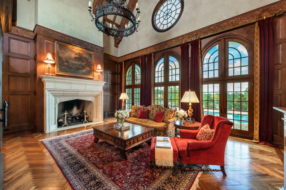This is an example of a large formal open concept living room in Atlanta with brown walls, dark hardwood floors, a standard fireplace, a concrete fireplace surround, brown floor and panelled walls.