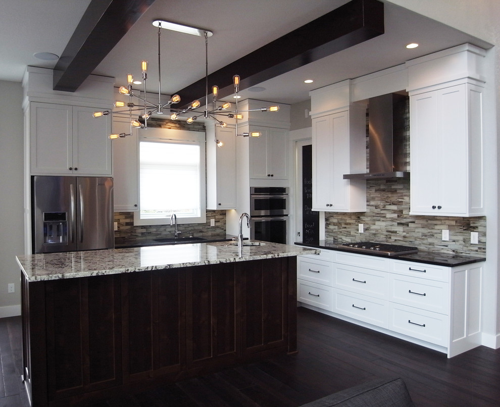 Transitional l-shaped open concept kitchen photo with white cabinets, stainless steel appliances, an island and flat-panel cabinets