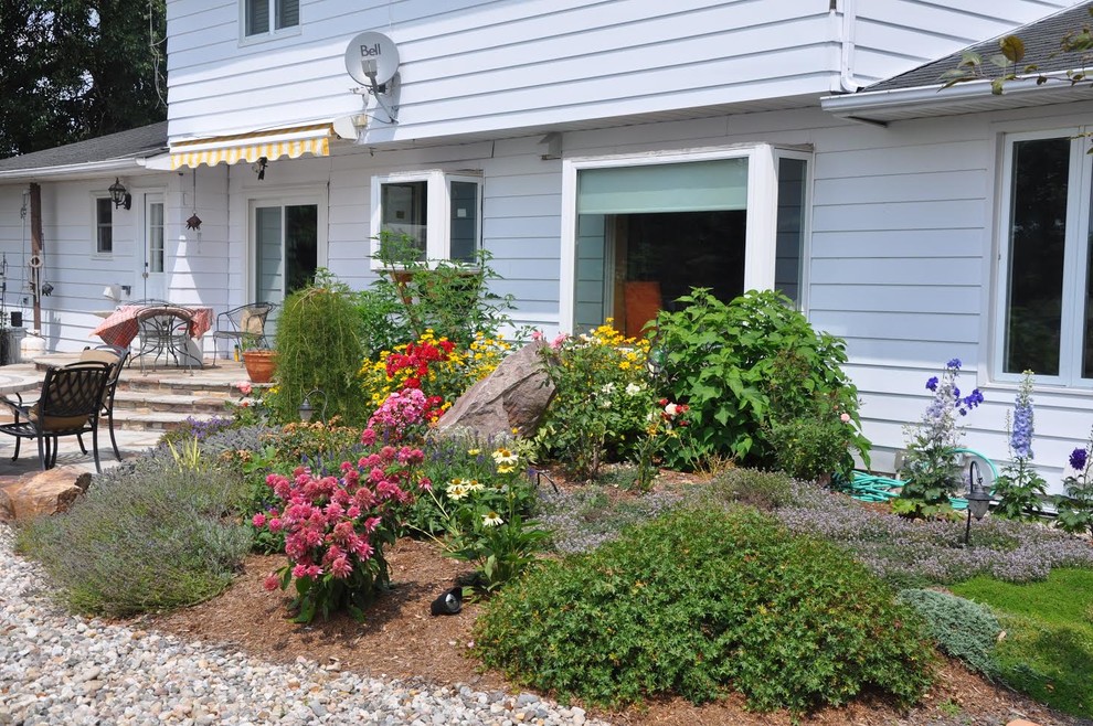 Design ideas for a large transitional backyard stone landscaping in Ottawa.