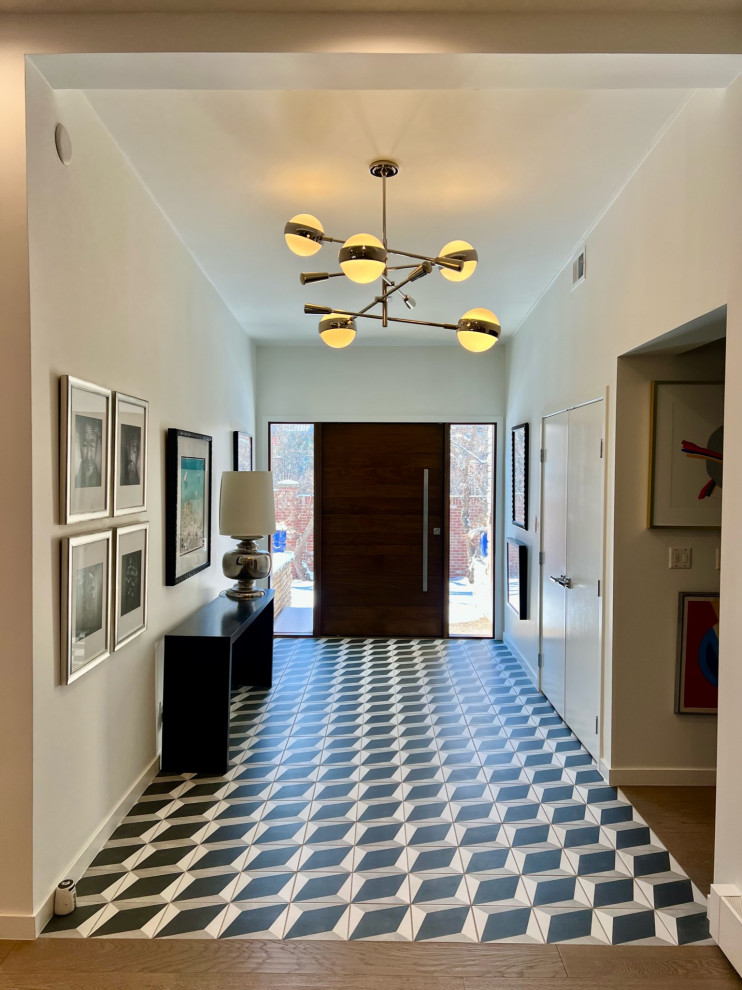 Esempio di un ingresso minimalista di medie dimensioni con pareti bianche, pavimento in gres porcellanato, una porta a pivot, una porta in legno bruno e pavimento multicolore