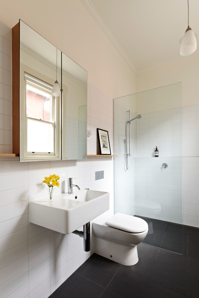 Photo of a mid-sized contemporary master bathroom in Melbourne with a wall-mount sink, an open shower, a wall-mount toilet, white tile, white walls, porcelain floors and an open shower.