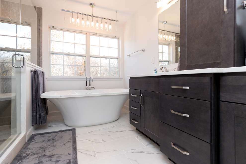 Mid-sized contemporary master bathroom in DC Metro with dark wood cabinets, a freestanding tub, white walls, an undermount sink, shaker cabinets, an alcove shower, a two-piece toilet, gray tile, porcelain tile, marble floors and engineered quartz benchtops.