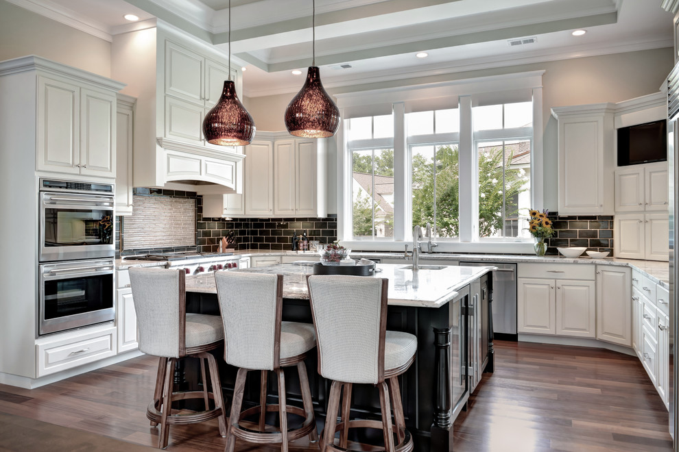 Inspiration for a traditional kitchen in Charleston with raised-panel cabinets, white cabinets, marble benchtops, black splashback, subway tile splashback, stainless steel appliances, medium hardwood floors and with island.