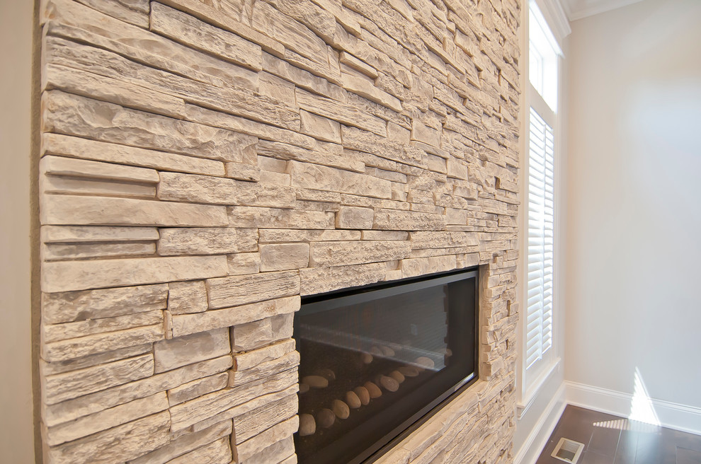 Example of a transitional master home design design with gray walls and a stone fireplace
