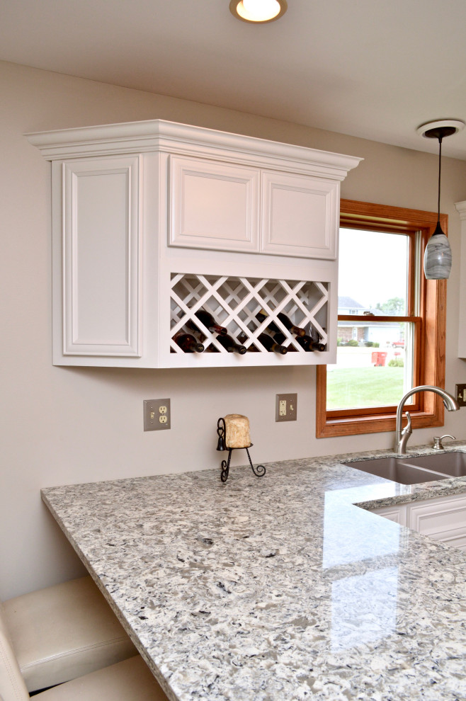Inspiration for a mid-sized transitional l-shaped eat-in kitchen remodel in Chicago with an undermount sink, recessed-panel cabinets, white cabinets, quartzite countertops, stainless steel appliances, a peninsula and gray countertops