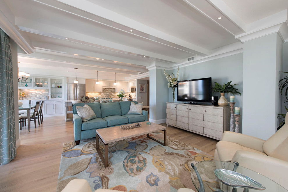 Inspiration for a large beach style open concept family room in Tampa with blue walls, light hardwood floors, a freestanding tv, a library, no fireplace and beige floor.