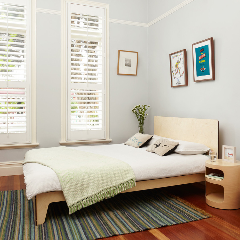 Photo of a contemporary bedroom in Melbourne with grey walls and medium hardwood floors.
