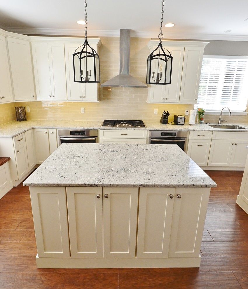 Open concept kitchen - large transitional galley medium tone wood floor open concept kitchen idea in Philadelphia with an undermount sink, white cabinets, granite countertops, beige backsplash, subway tile backsplash, stainless steel appliances, two islands and shaker cabinets