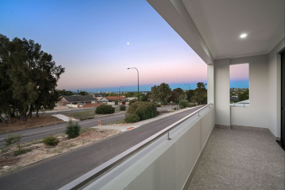 Photo of a small contemporary balcony in Perth with a roof extension and metal railing.