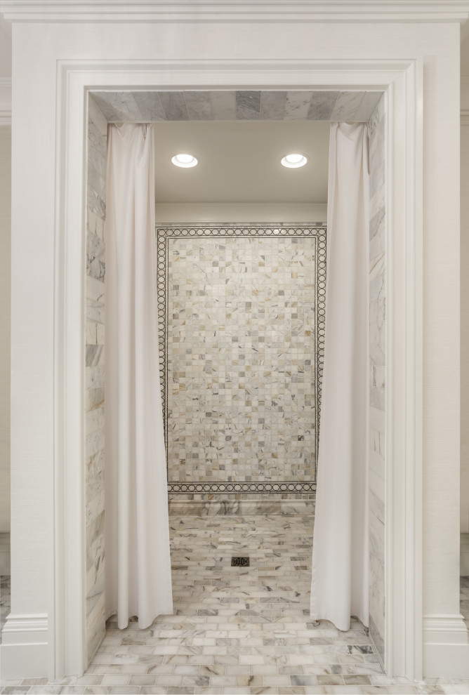 Large transitional master white tile and marble tile marble floor and gray floor walk-in shower photo with furniture-like cabinets, white cabinets, a two-piece toilet, white walls, an undermount sink, marble countertops and white countertops