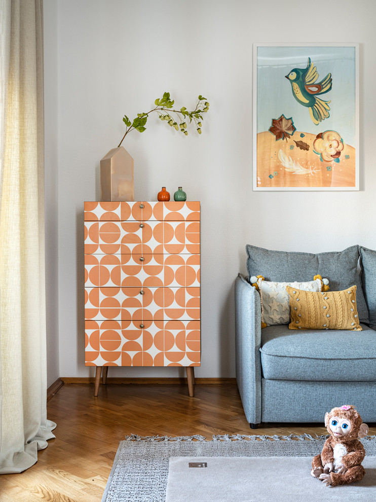 Idée de décoration pour une grande chambre d'enfant de 1 à 3 ans design avec un mur beige, un sol en bois brun et un sol marron.