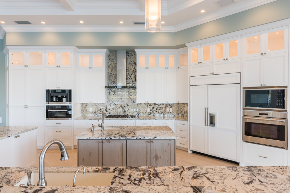 Example of a large transitional galley porcelain tile eat-in kitchen design in Miami with white cabinets, granite countertops, white appliances, an island, an undermount sink and beaded inset cabinets